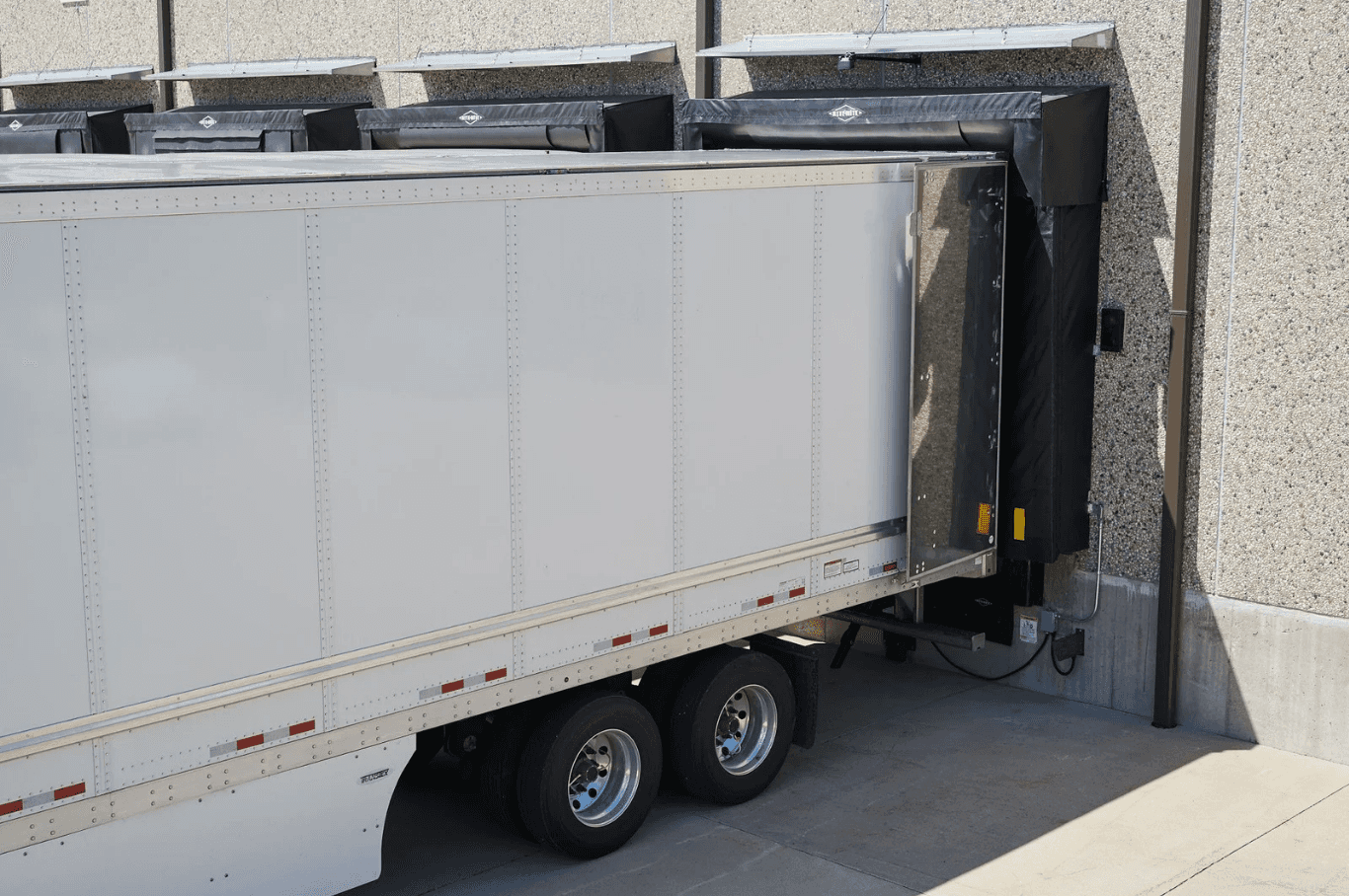 Caja de tráiler acoplada a un andén con sello de andén instalado