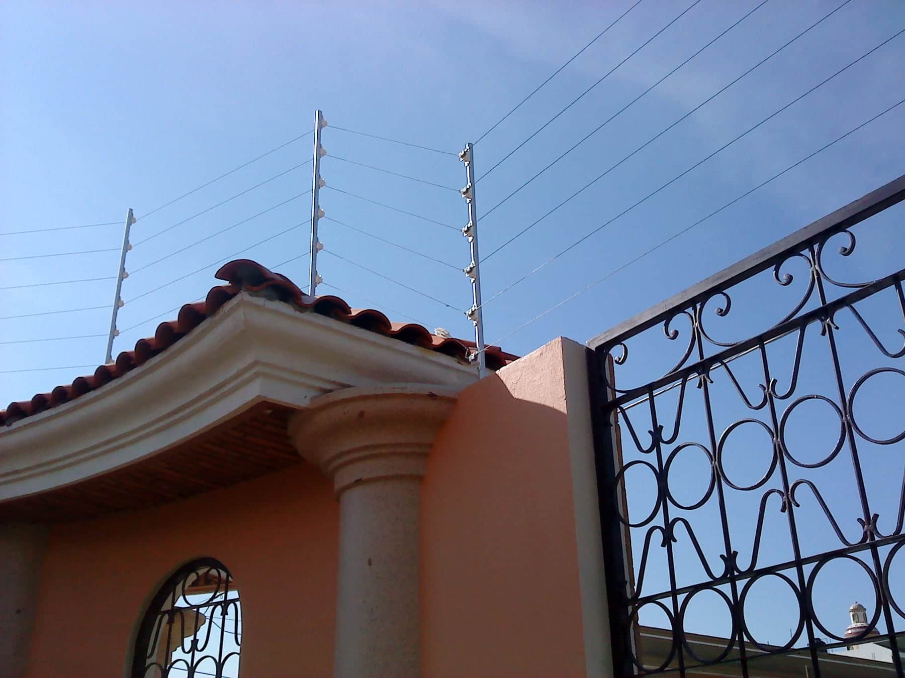 Casa con cerca eléctrica instalada sobre la barda